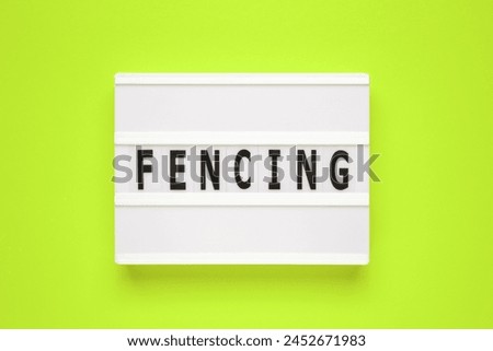 The word fencing on lightbox isolated green background.