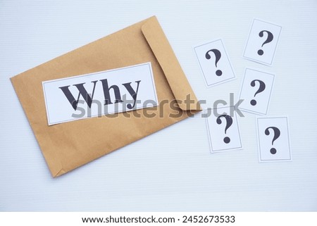 Brown envelope and printed question word Why and question marks. Concept Teaching aid. Education materials for teach WH- question. Asking questions. Suspicious symbol to find reason                   