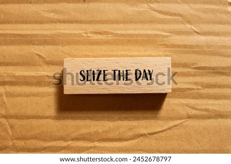 Seize the day words written on wooden block with cardboard background. Conceptual seize the day symbol. Copy space. Royalty-Free Stock Photo #2452678797