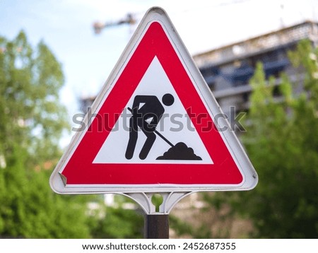 A construction sign with a triangle design. Road works sign. Red triangle sign with silhouette working person inside