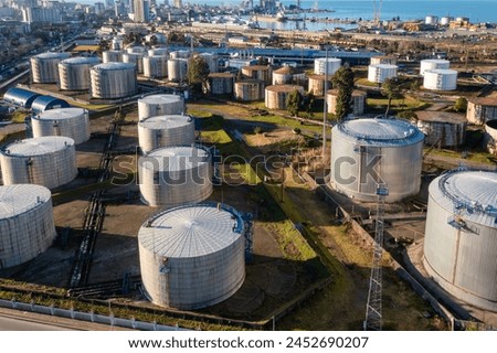 Aerial view of oil tanks at oil refinery. Gas and oil steel storage containers. Tank farm storage chemical petroleum petrochemical refinery product at oil terminal. Petrol industrial plant Royalty-Free Stock Photo #2452690207