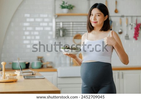 pregnancy, healthy food and people concept - close up of happy pregnant woman eating vegetable salad for breakfast in bed at home. Child and Maternity prenatal care concept.