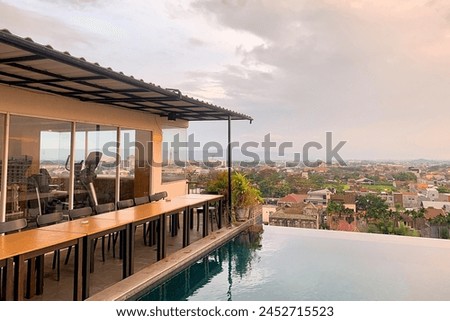 Beautiful view of the sky at sun going down from the top of a stunning hotel with swimming pool and views of Yogyakarta city. Royalty-Free Stock Photo #2452715523