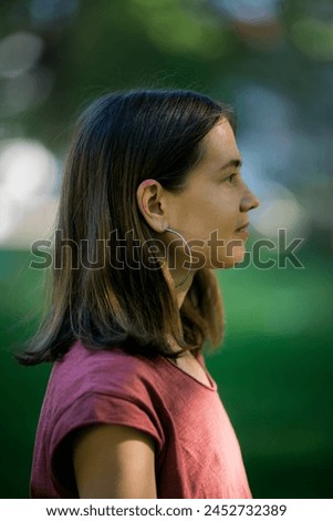 Captured in profile, the woman maintains a serene expression, exuding calmness and poise. Royalty-Free Stock Photo #2452732389