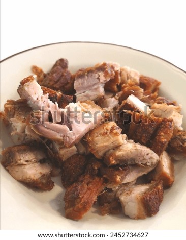 Close up photo of chopped crispy deep fried pork in a brown color dish. Selective focus. 