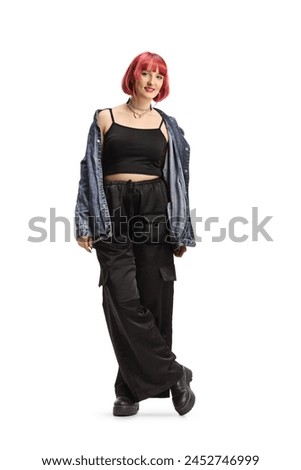Young female with red heair wearing black wide trousers and jeans shirt off shoulders isolated on white background