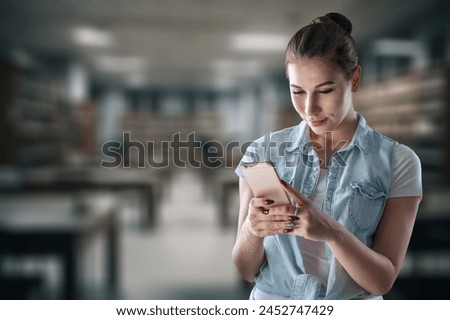 Girl student hold mobile phone in university Royalty-Free Stock Photo #2452747429