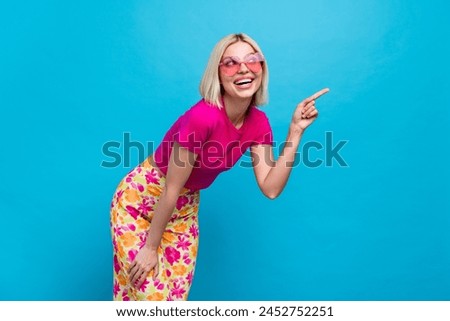 Photo portrait of attractive young woman sunglass point look empty space dressed stylish pink clothes isolated on blue color background