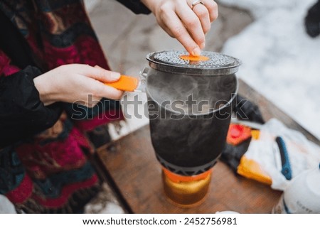 Steam comes out of a pot that stands on a gas burner, a camping kitchen, camping utensils, a cooking pot. High quality photo