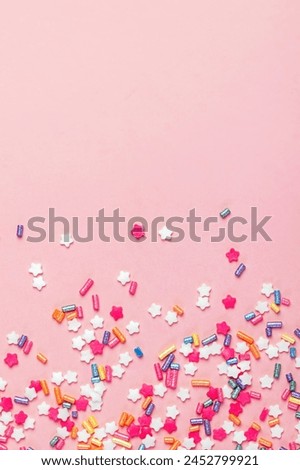 Festive sugar sprinkles on pastel pink background