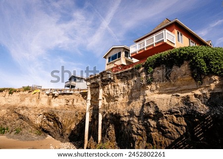 A house on top of a steep cliff overlooking the ocean, almost sliding into the ocean. Home of seaside bluff, almost falling down Royalty-Free Stock Photo #2452802261