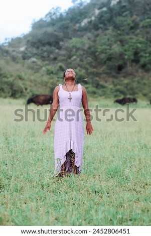 Black woman, from the Northeast representing the Northeast of Brazil. she is in a natural environment, contemplating nature and giving thanks. Royalty-Free Stock Photo #2452806451