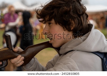 A teenager shoots a recreational crossbow at a shooting range. Royalty-Free Stock Photo #2452810805
