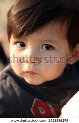 Interior photo view of close up head shot face of handsome cute good looking kid 1 year old eurasian asian chinese child baby children boy portrait with adorable curious wondering natural expression