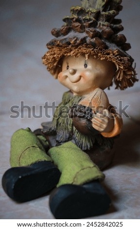 image of a cute cartoon show pieces with a big hat and nut in his hand in green dress and large boot, dwarf portrait, folklore