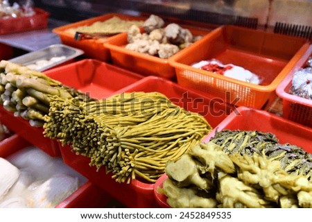 A close-up shot of a market stall with pickled green beans: Tangy, flavorful, and nutritious! Packed with vitamins and minerals. Boosts digestion and immunity. Traditional and delicious! Royalty-Free Stock Photo #2452849535