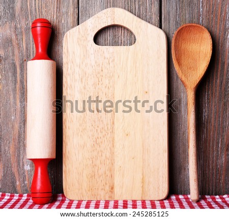 Cutting board with cherry tomatoes and lettuce on wooden planks background