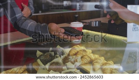 Image of spots of light over man serving coffee working in cafe. Global networks, business, finance, computing and data processing concept digitally generated image.