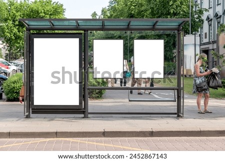 Three Blank Vertical Mockups Of Bus Stop Billboards In Front Of A City Park. Empty White Advertising Screens On The Sidewalk