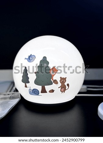 Small globe lamp for children's room. Lamp with animal cartoons. Cute cartoons on lamp globe for children. Emitting a soft white light, it creates a cozy atmosphere perfect for bedtime stories.