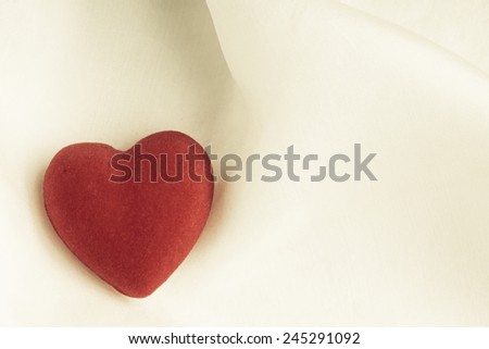 Valentine's day or wedding. Red wooden decorative heart on abstract white background luxury cloth silk or satin textile with copy space
