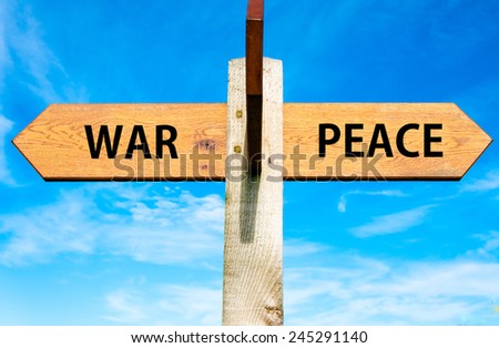 Wooden signpost with two opposite arrows over clear blue sky, War versus Peace messages