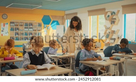 Primary School Children Getting Modern Education and Learning New Skills: Teacher Passing Between Desks, Helping Smart Diverse Kids with Classwork. Schoolchildren Resolving Assignments in Textbooks