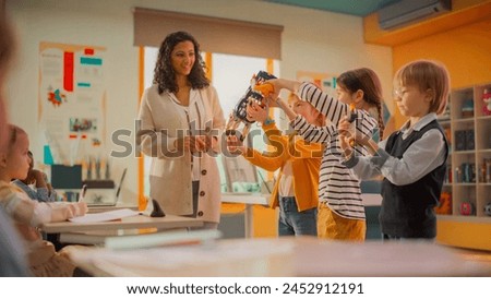 Smart Boy and Two Talented Girls Making a Presentation About a Giant Mechanical Hand that Moves on Hydraulic Power. Young Future Engineers Studying Science and Technology in Primary School Royalty-Free Stock Photo #2452912191