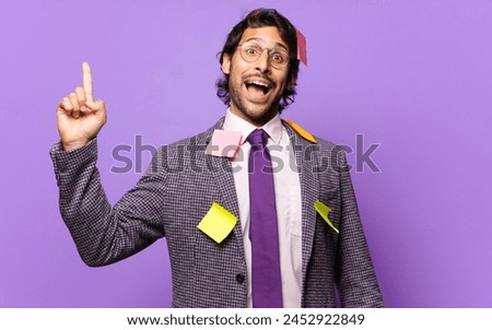 young handsome indian man feeling like a happy and excited genius after realizing an idea, cheerfully raising finger, eureka!. humorous business concept