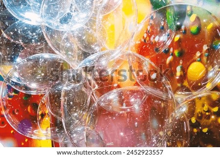 A large number of transparent plastic bubbles floating in the air. The balls are in a colorful red-yellow room, creating a visually attractive and playful atmosphere Royalty-Free Stock Photo #2452923557