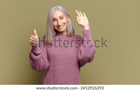 senior woman feeling happy, amazed, satisfied and surprised, showing okay and thumbs up gestures, smiling