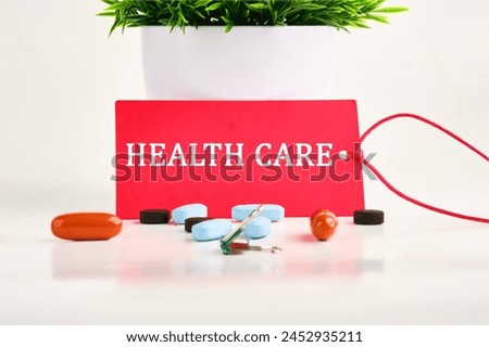 Medical concept. Health Care on a red card with pills lying next to it