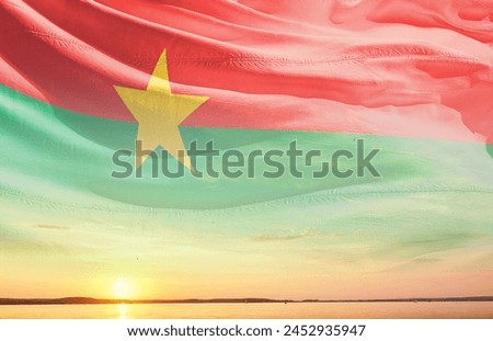 Burkina Faso waving flag in the beautiful sky.