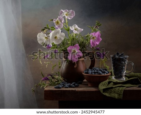 Modern still life with a bouquet of petunias and honeysuckle on a wooden table.
