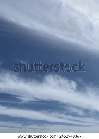 blue sky with clouds like waves Royalty-Free Stock Photo #2452948367