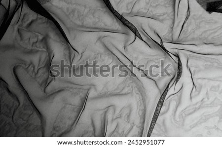 Full frame of thin black flexible clothing fabric sheet material photography for social media, prints, or website wallpaper and backdrop isolated on horizontal ratio copy spaced background.
