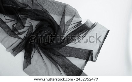 Thin black flexible clothing swirling spiral curl fabric sheet material photography for social media, prints, or website wallpaper and backdrop isolated on horizontal ratio background.
