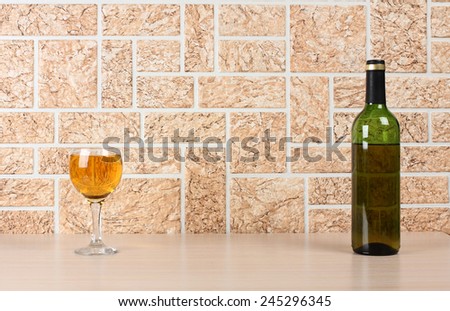 Wine bottle and glass on brick wall background