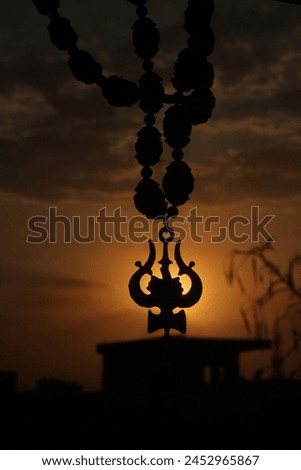Lord Shiva Trishul with Sun set Royalty-Free Stock Photo #2452965867