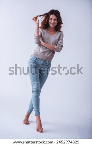 Portrait of a full-grown happy young beautiful girl on a white background smiling at the camera Royalty-Free Stock Photo #2452974825