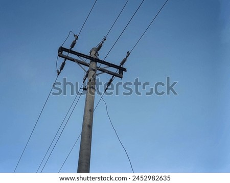 Electric tranformer on the eletric Cement-pole. White clouds and blue sky Royalty-Free Stock Photo #2452982635