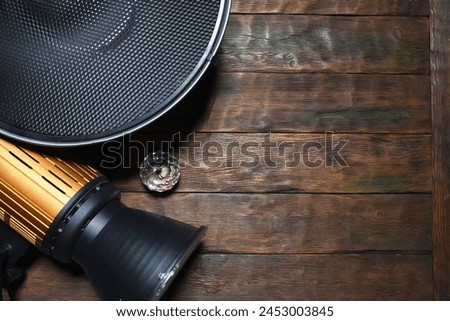 Photo studio equipment concept top view background with copy space. Photostudio led constant light sources and different light modifiers on the wooden table background. Royalty-Free Stock Photo #2453003845