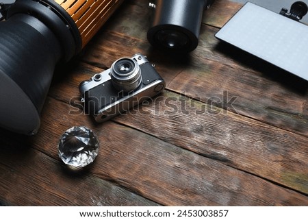 Photo studio equipment concept top view background with copy space. Photostudio led constant light sources and different light modifiers on the wooden table background. Royalty-Free Stock Photo #2453003857