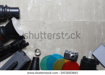 Photo studio equipment concept top view background with copy space. Photostudio led constant light sources and different light modifiers on the wooden table background. Royalty-Free Stock Photo #2453003865