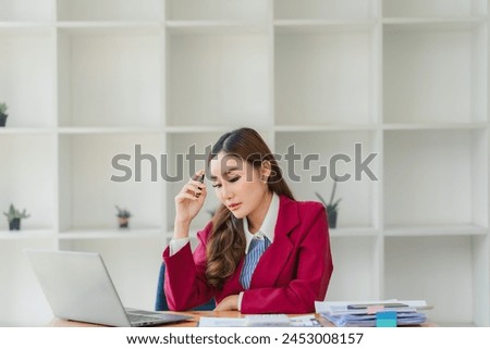 Asian women are stressed while working on laptop, Tired asian businesswoman with headache at office, feeling sick at work, copy space Royalty-Free Stock Photo #2453008157