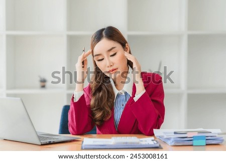 Asian women are stressed while working on laptop, Tired asian businesswoman with headache at office, feeling sick at work, copy space Royalty-Free Stock Photo #2453008161