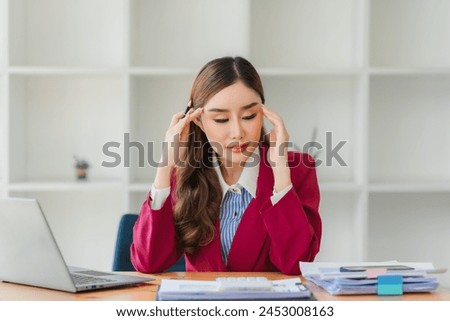 Asian women are stressed while working on laptop, Tired asian businesswoman with headache at office, feeling sick at work, copy space Royalty-Free Stock Photo #2453008163