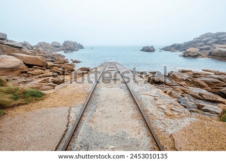 Guide rails for lowering fishing boats on the pink granite coast at Ploumanac'h in Brittany, France. Royalty-Free Stock Photo #2453010135
