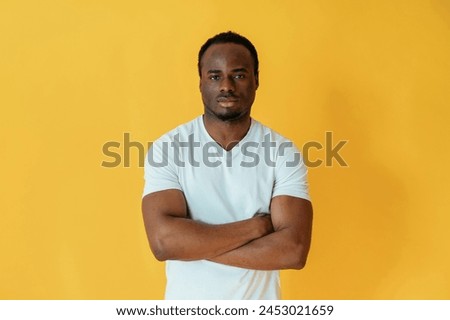 Black man is in the studio against yellow background.