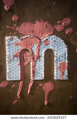 Red paint drops on letter m of a traffic sign